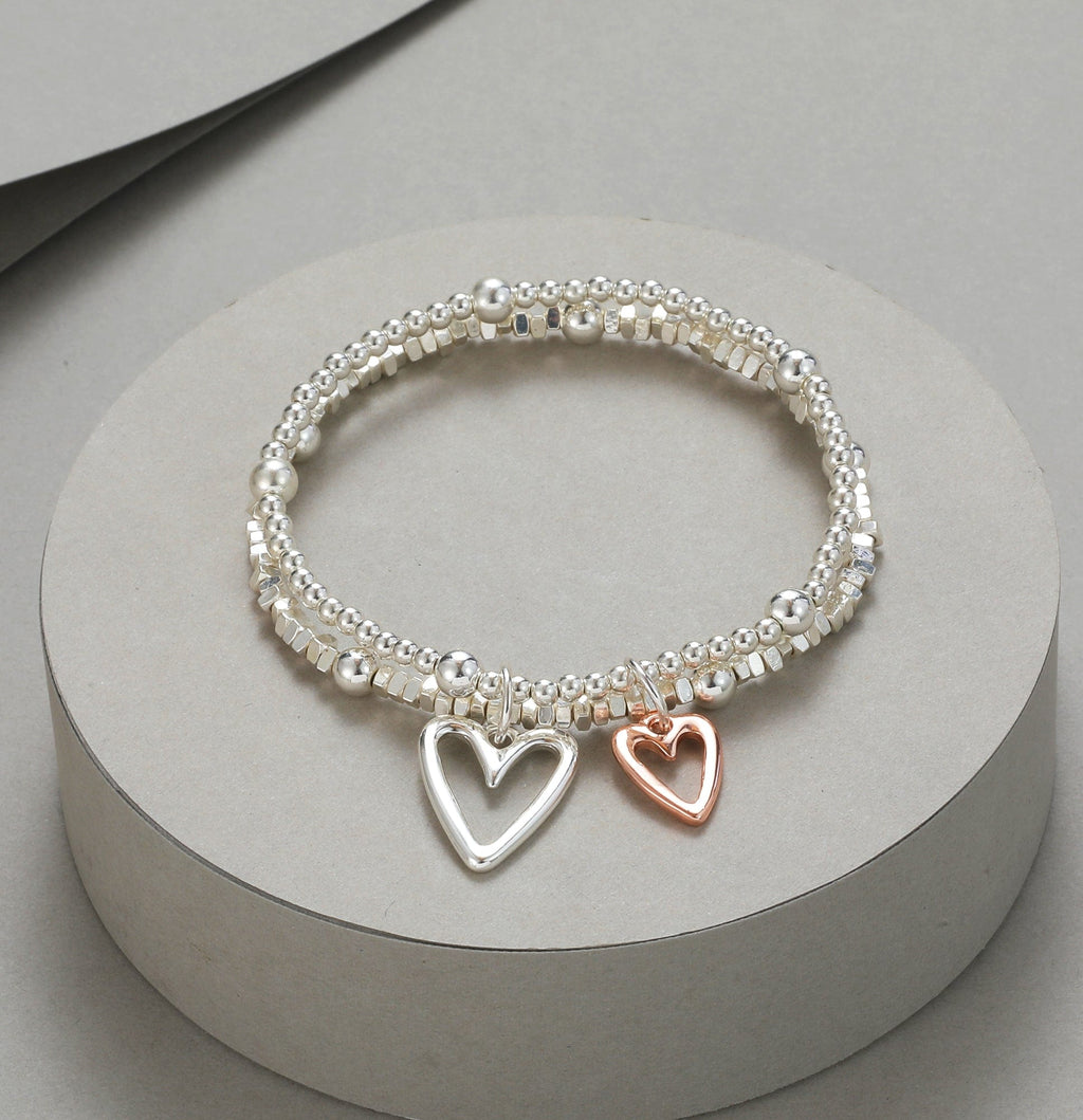 lusciousscarves Gracee Silver Double Strand Stretchy Bracelet with 2 Silhouette Rose Gold and Silver Heart Charms .